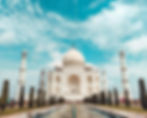 An image of the Taj Mahal, there is a fountain in the image and multiple trees, the sky is blue, used on the website of POOLit the carpool app