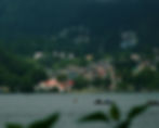 an image of the Naini lake in Nainital, there are hills in the back and the sky is cloudy