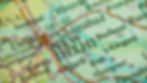 Close-up map showing New Delhi and nearby cities with bold text, colorful lines, and symbols indicating roads and locations.